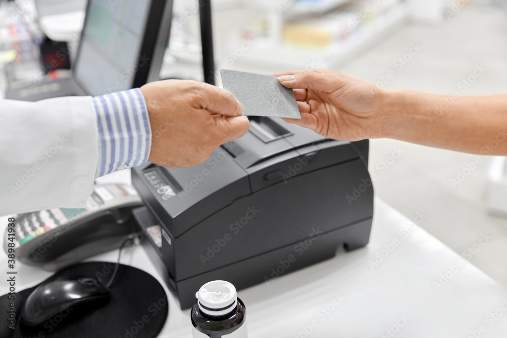 medicine, payment and finance people concept - close up of hand giving bank card to pharmacist medicine, payment and finance people concept - close up of hand giving bank card to pharmacist