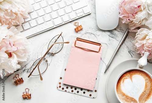 Fototapeta Naklejka Na Ścianę i Meble -  Flat lay top view women's office desk with flowers. Female workspace with laptop, flowers peonies, accessories, notebook, glasses, cup of coffee on white background.