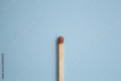  Match on a blue background close-up. Minimalism concept, pastel colors. Top view, flat lay