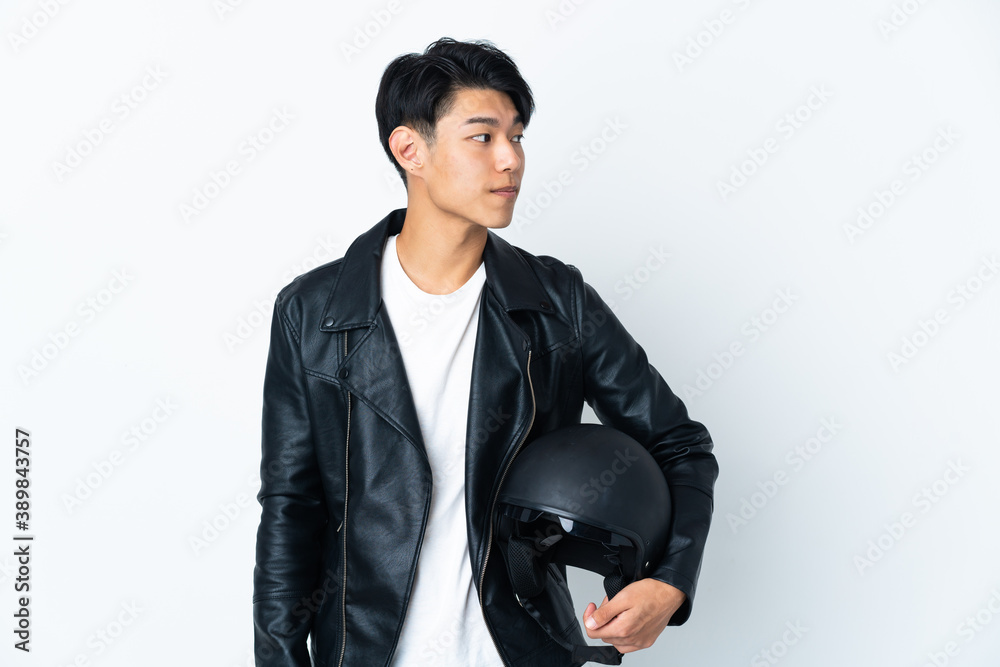 Chinese man with a motorcycle helmet isolated on white background looking to the side Chinese man with a motorcycle helmet isolated on white background looking to the side