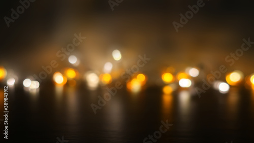 Dark abstract background with neon blurred golden lights. Reflection on the surface of the golden bokeh. Flames, smoke, fire.