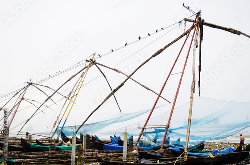 Chinese fishing nets at Kochi beach in Kerala. Local Indian fisherman catching fish from water in Indian Ocean