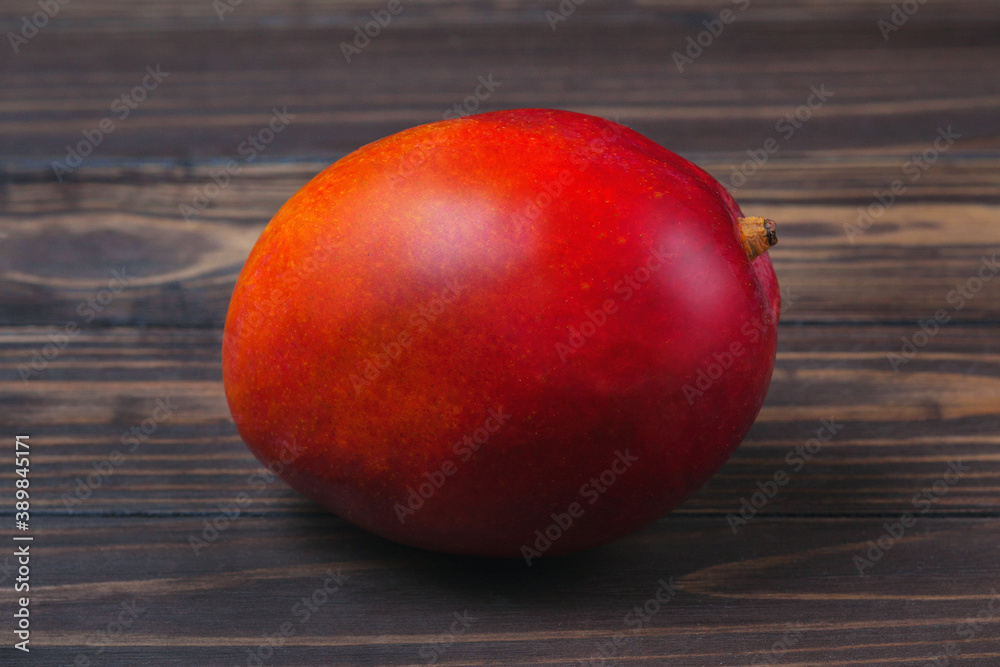 Ripe mango fruit, lies on a background of wooden boards Ripe mango fruit, lies on a background of wooden boards