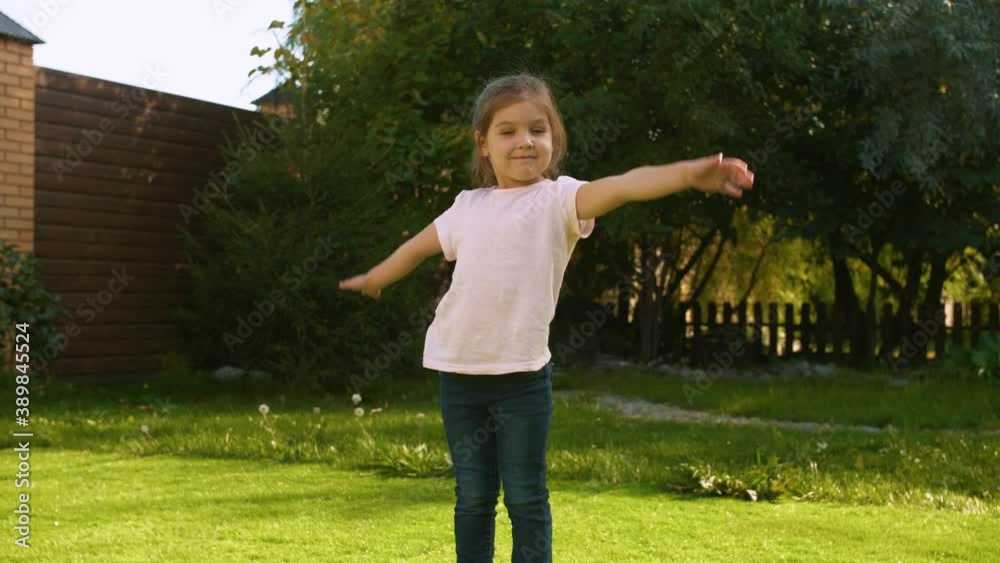 Little Caucasian beautiful girl depicts the plane with her arms outstretched to the sides like wings. Positive emotions, non-verbal gestures. Everyday leisure Little Caucasian beautiful girl depicts the plane with her arms outstretched to the sides like wings. Positive emotions, non-verbal gestures. Everyday leisure