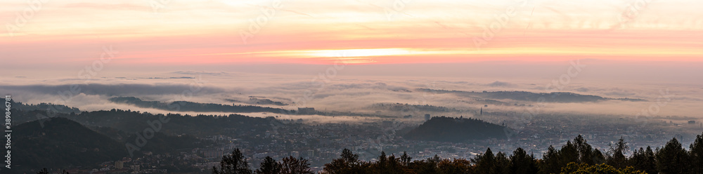 Panorama of Graz city covered if fog on autumn morning during sunraise.