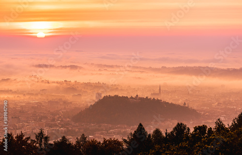 Graz city covered if fog on autumn morning during sunraise.