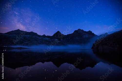 Summer night under Milky way in Ibon De Estanes lake, Aragon Pyrenees, Spain