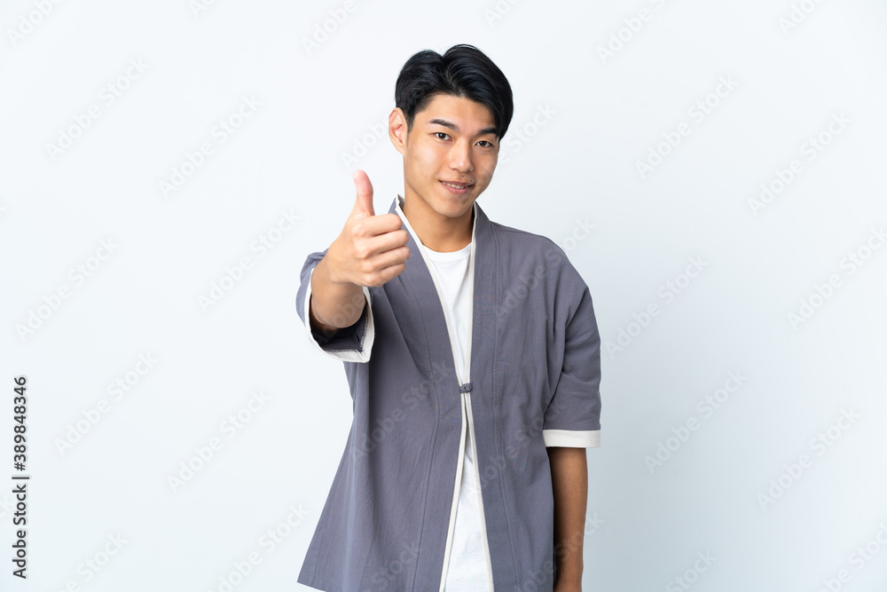 Young Chinese man isolated on white background with thumbs up because something good has happened Young Chinese man isolated on white background with thumbs up because something good has happened