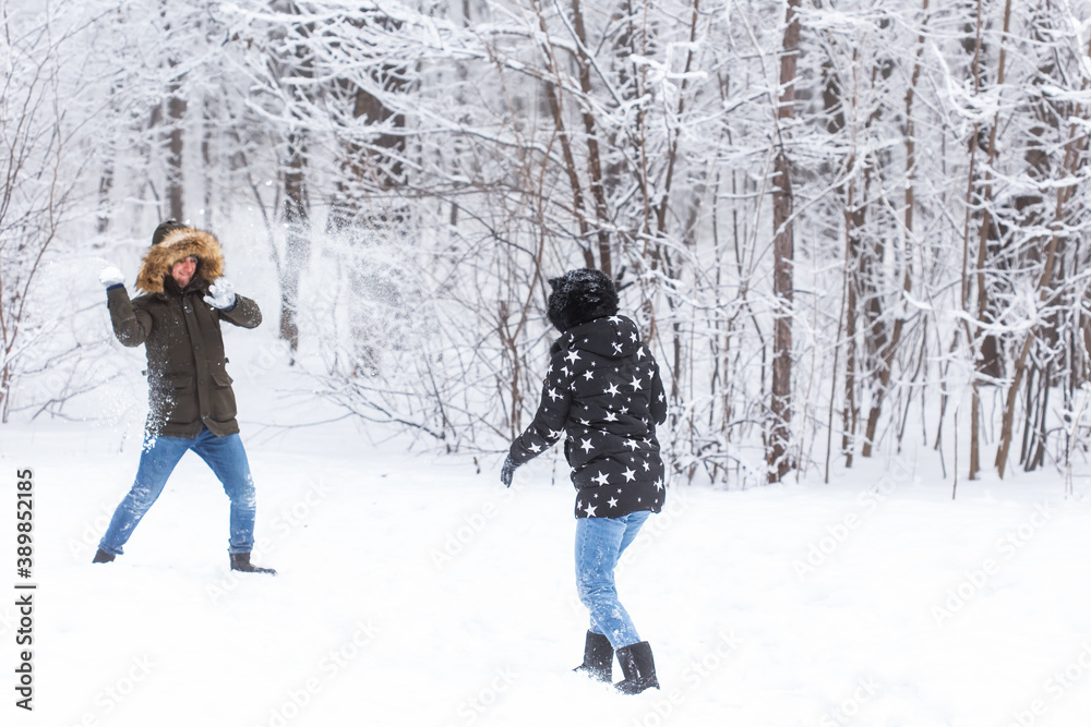 Fun, season and leisure concept - love couple plays winter wood on snow