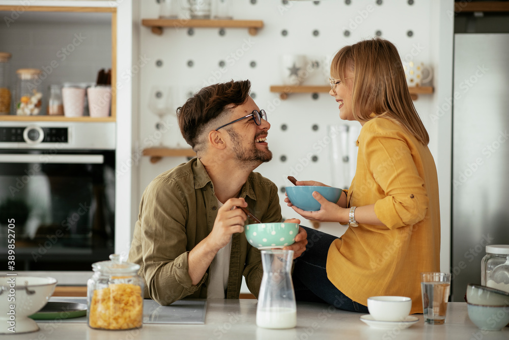 Young couple eating breakfast at home. Loving couple enjoying in the kitchen... Young couple eating breakfast at home. Loving couple enjoying in the kitchen...