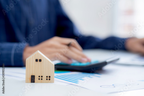 Hand of business man agent calculating loan of finance and investment for real estate, businessman and invest in property about home, construction or mortgage of home, male using calculator. photo