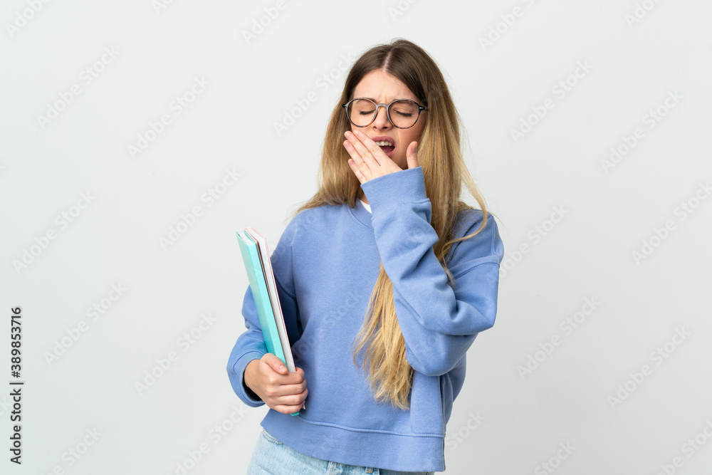 Young blonde student woman isolated on white background yawning and covering wide open mouth with hand Young blonde student woman isolated on white background yawning and covering wide open mouth with hand
