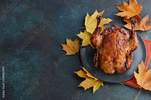 Photo Roasted turkey or chicken dish decorated with autumn maple leaves for Thanksgivi
