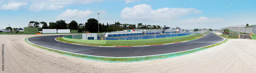 Fototapeta premium Asphalt motor sport circuit turn wide panoramic view of track and external gravel trap