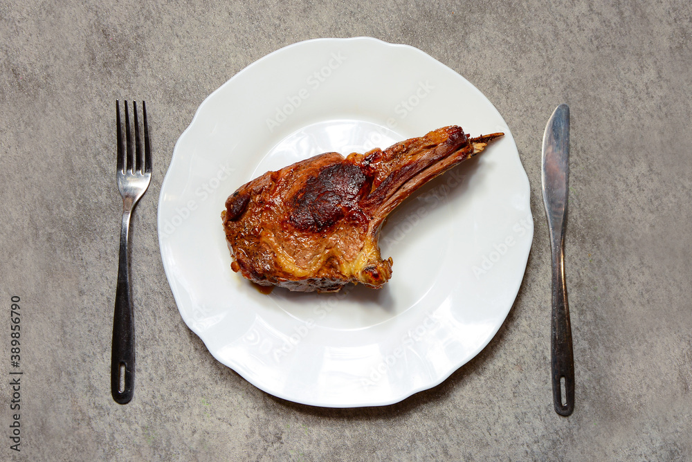 Grilled, fried, Raw beef meat steak with fork and knife on white plate on light background top view. Carnivore, keto Grilled, fried, Raw beef meat steak with fork and knife on white plate on light background top view. Carnivore, keto