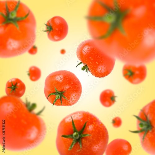 Many red tomatoes free falling on light yellow background. Selective focus - shallow depth of field.