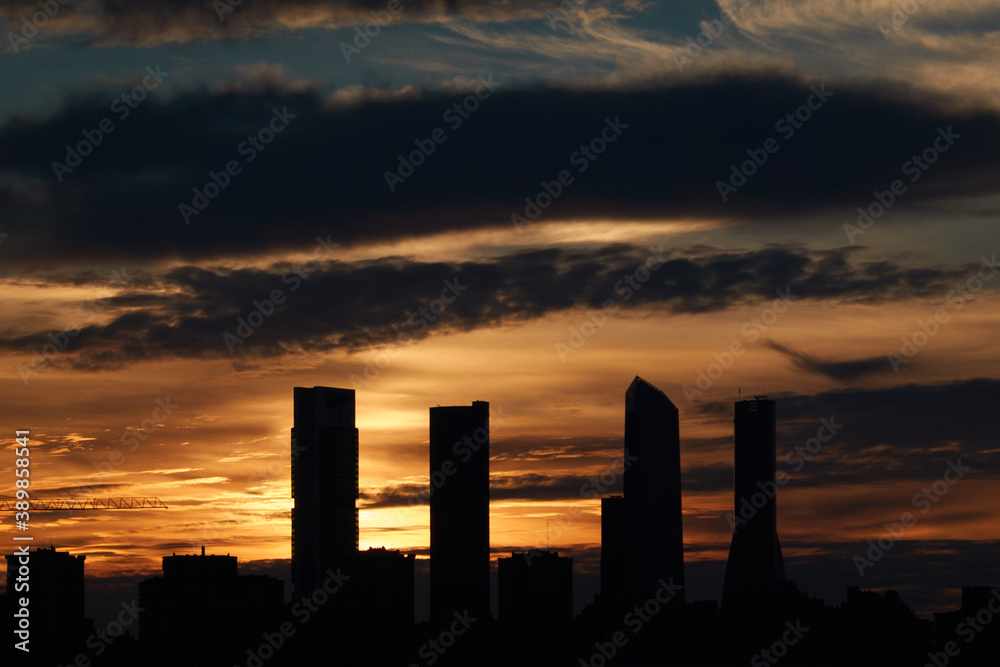 The sunset behind the Cuatro Torres de Madrid seen from the Valdebebas forest park. Spain
