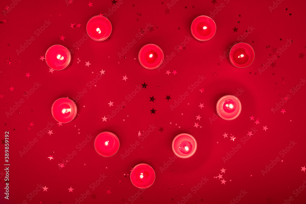 Christmas evening or Valentines composition made from burning candles, glitter on red surface. Merry christmas and happy 2021 New Year, Happy Valentine concept. Flat lay, top view Christmas evening or Valentines composition made from burning candles, glitter on red surface. Merry christmas and happy 2021 New Year, Happy Valentine concept. Flat lay, top view