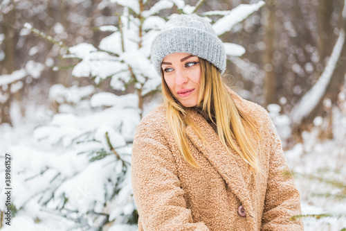 Attractive young woman in winter time outdoor. Snow, holidays and season concept.