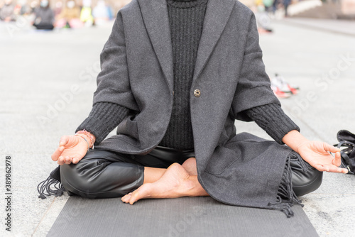 Yoga teachers protesting against the blockade and restrictions of Covid-19 in a square in Brescia, Italy. Shot of the hands resting on the knees of the crossed legs. People are meditating. © OlgaLitvinovaFoto