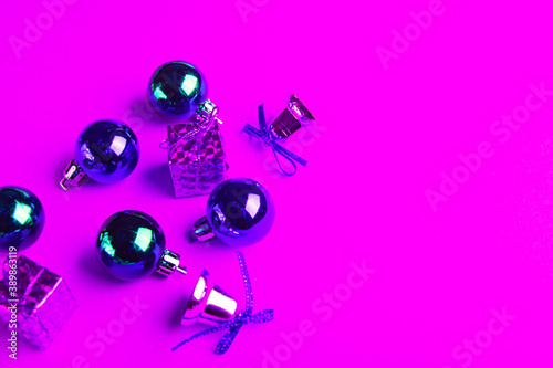 Christmas balls, gifts and sparkling bells in neon light.