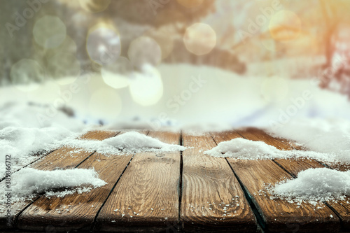 Snow on a wooden table in alpine mountain surroundings on a beautiful winter day