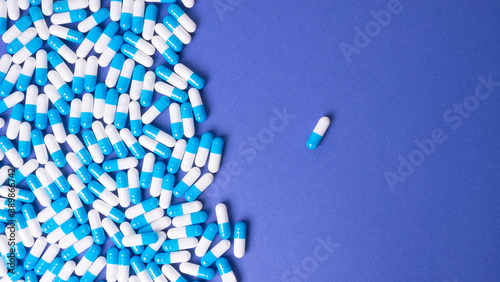 white and blue pills on a blue background. medical background