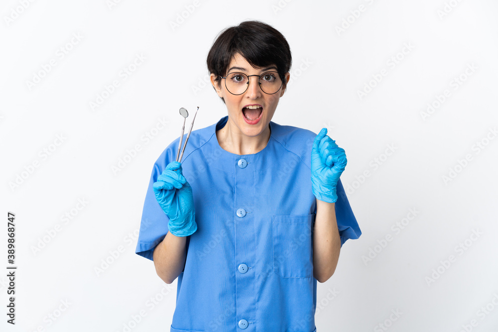 Dentist woman holding tools isolated on white background celebrating a victory in winner position Dentist woman holding tools isolated on white background celebrating a victory in winner position