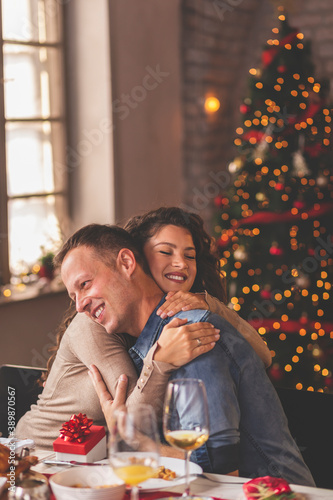 Husband and wife exchanging presents during Christmas dinner