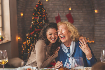 Mother and daughter hugging over Christmas dinner