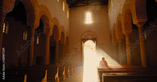 Vichingo o normanno con cotta di maglia in testa mentre prega in chiesa in ginocchio.
