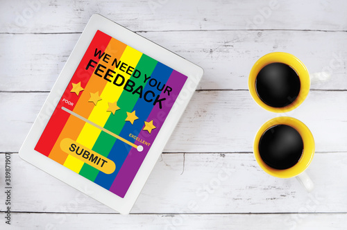 LGBT business rating application review on computer tablet with cup of coffee on table. Five stars feedback concept and business success technology idea