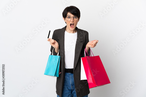 Woman with short hair isolated on white background holding shopping bags and surprised