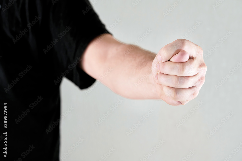 A man hand clenched into a fist shows a fig