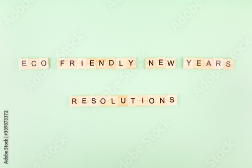 Phrase "Eco friendly new year's resolutions" in wooden letters on green background