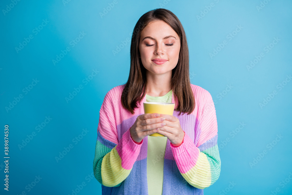 Photo of dreamy happy brown haired young woman drink coffee hold mug closed eyes isolated on blue color background Photo of dreamy happy brown haired young woman drink coffee hold mug closed eyes isolated on blue color background