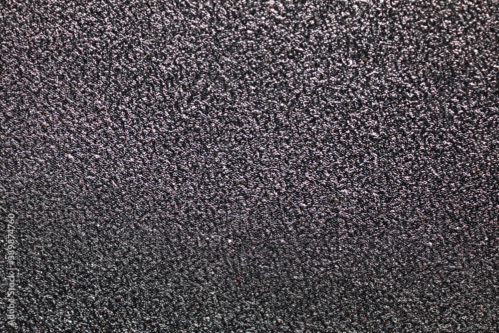 Fototapeta premium Dark gray textured surface background with rough grainy pattern and subtle metallic sheen, abstract material design, this abstract material design provides a gritty and industrial aesthetic