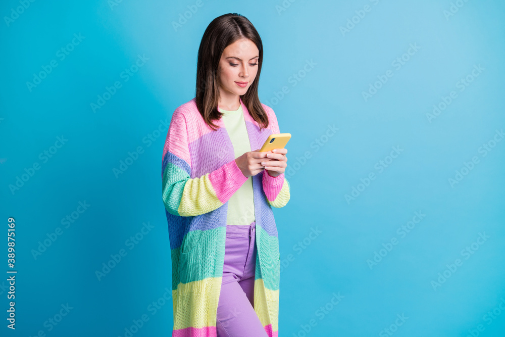 Photo of attractive brown haired woman hold look phone addicted user isolated on shine blue color background Photo of attractive brown haired woman hold look phone addicted user isolated on shine blue color background
