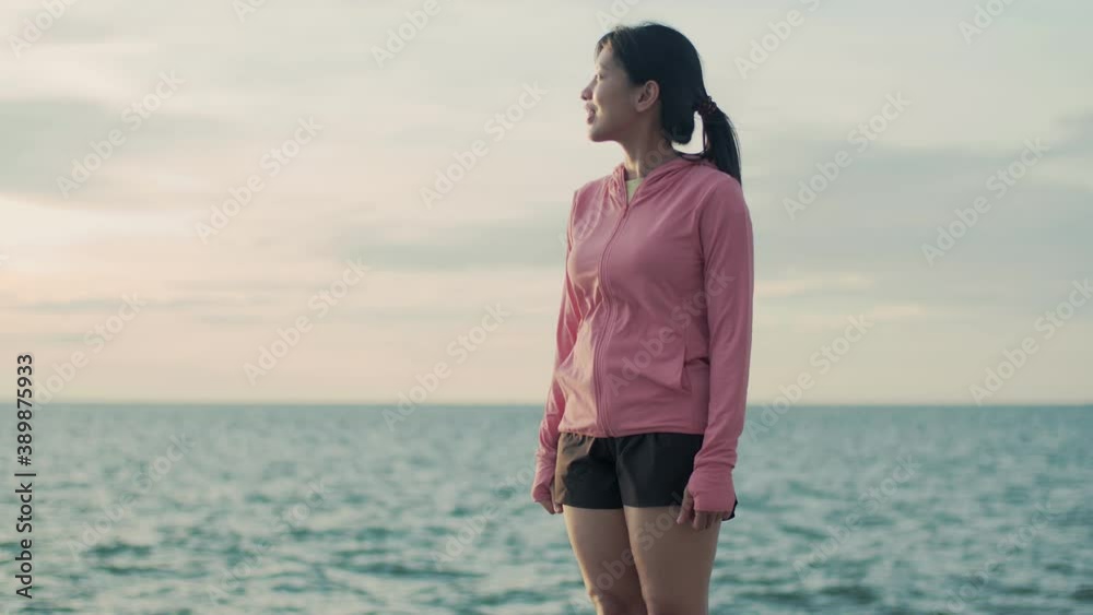 Young Asian females relaxed enjoying peaceful sunset and looking up exhaling fresh air relaxing at the beautiful landscape ocean view. Young Asian females relaxed enjoying peaceful sunset and looking up exhaling fresh air relaxing at the beautiful landscape ocean view.