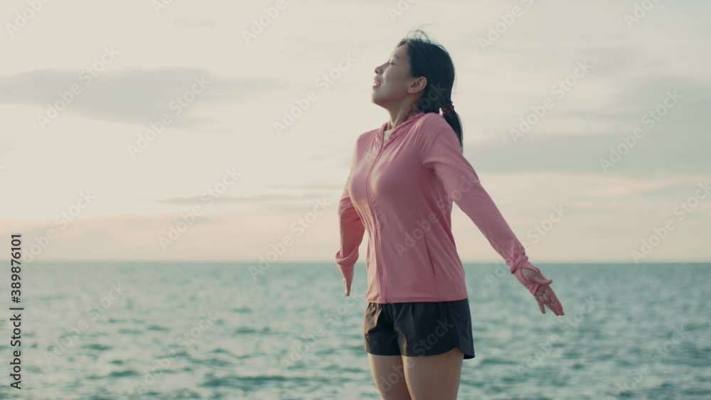 Portrait of young asian female relaxed enjoying peaceful sunset and looking up exhaling fresh air relaxing at the beautiful landscape ocean view. Portrait of young asian female relaxed enjoying peaceful sunset and looking up exhaling fresh air relaxing at the beautiful landscape ocean view.