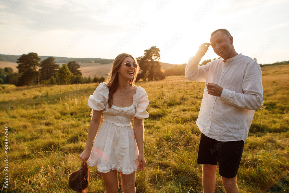 Fototapeta premium happy young couple at sunset in the field