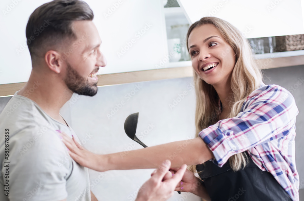 Smiling young couple cooking food in the kitchen Smiling young couple cooking food in the kitchen