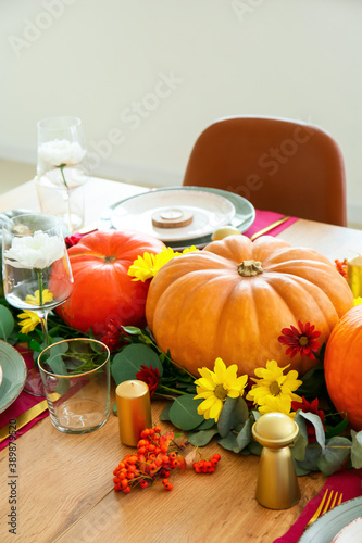 Beautiful table setting with pumpkins in dining room