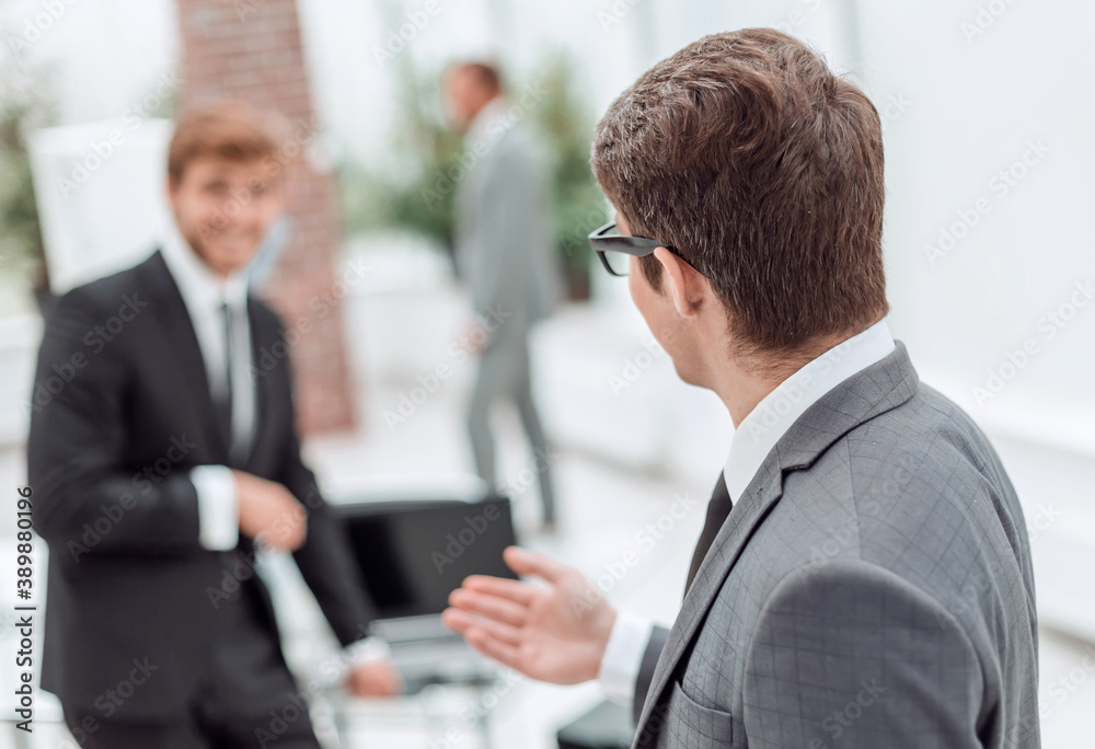 side view. friendly businessman standing in the office.