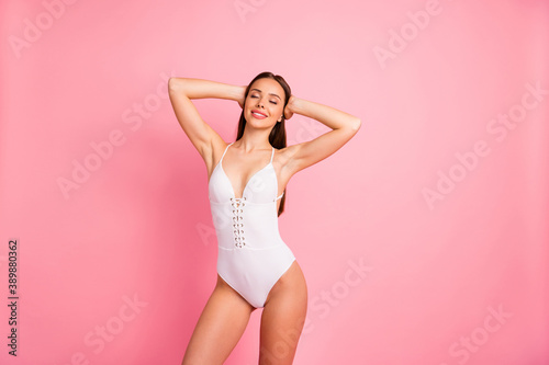 Portrait of her she nice-looking attractive lovely winsome sweet sportive cheerful cheery straight-haired lady having rest in one-piece suit isolated over pink pastel background