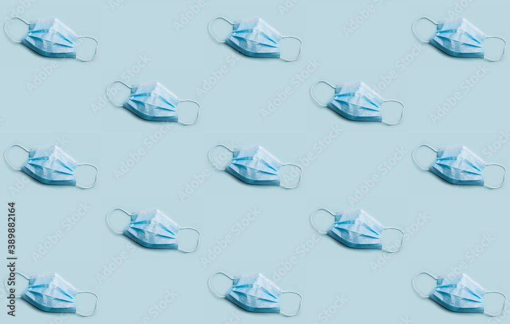 Obraz premium Bizarre medical mask wallpaper concept. Blue disposable virus prevention masks on red background. 