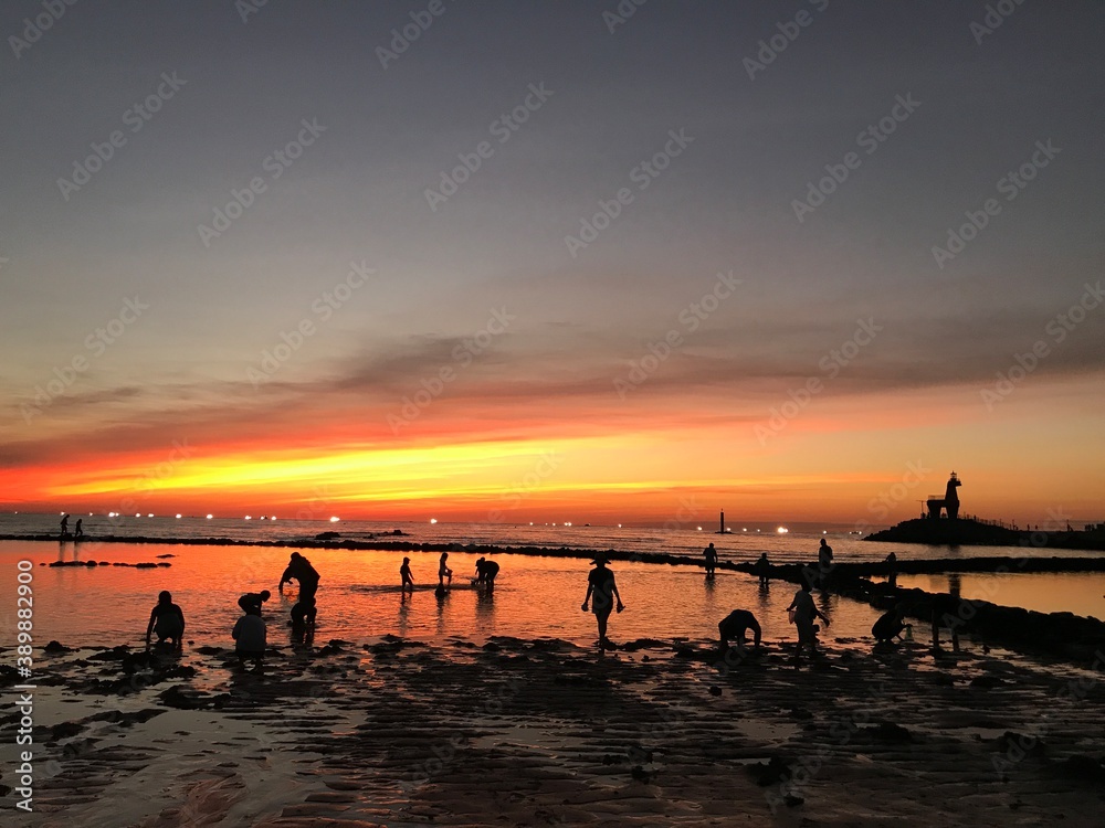 Fototapeta premium beautiful sunset at mudflat and happy people