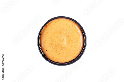 Sauce mustard cheese in a plastic disposable dish on a white background, top view. Isolated