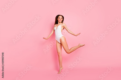 Full size photo of cheerful youth raise hands legs smile dressed swim wear isolated over pink background