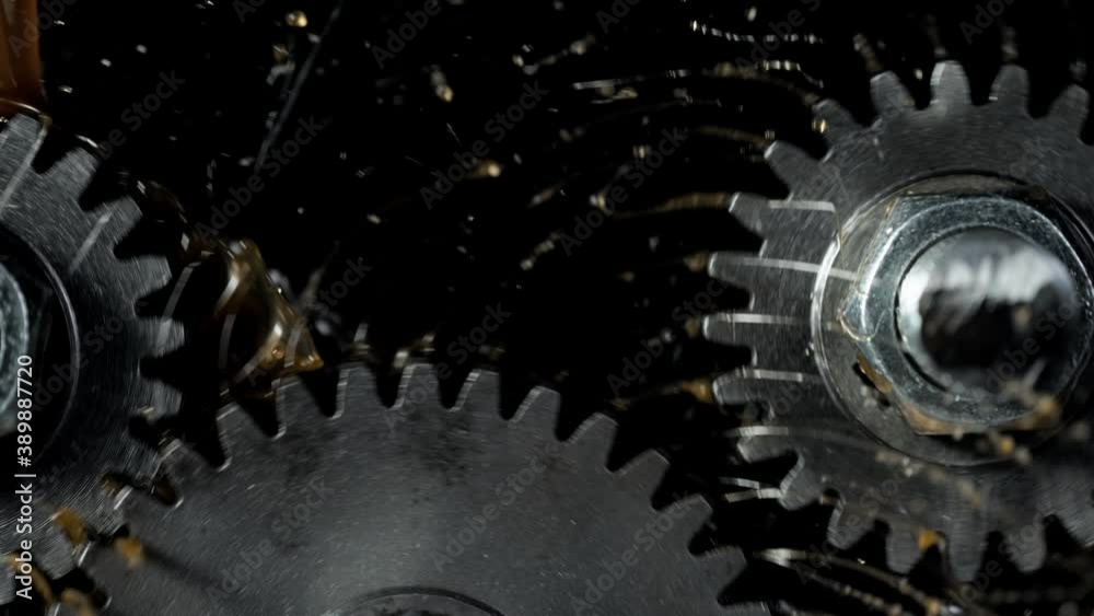 Super slow motion of rotating engine steel wheels with oil splashes ...